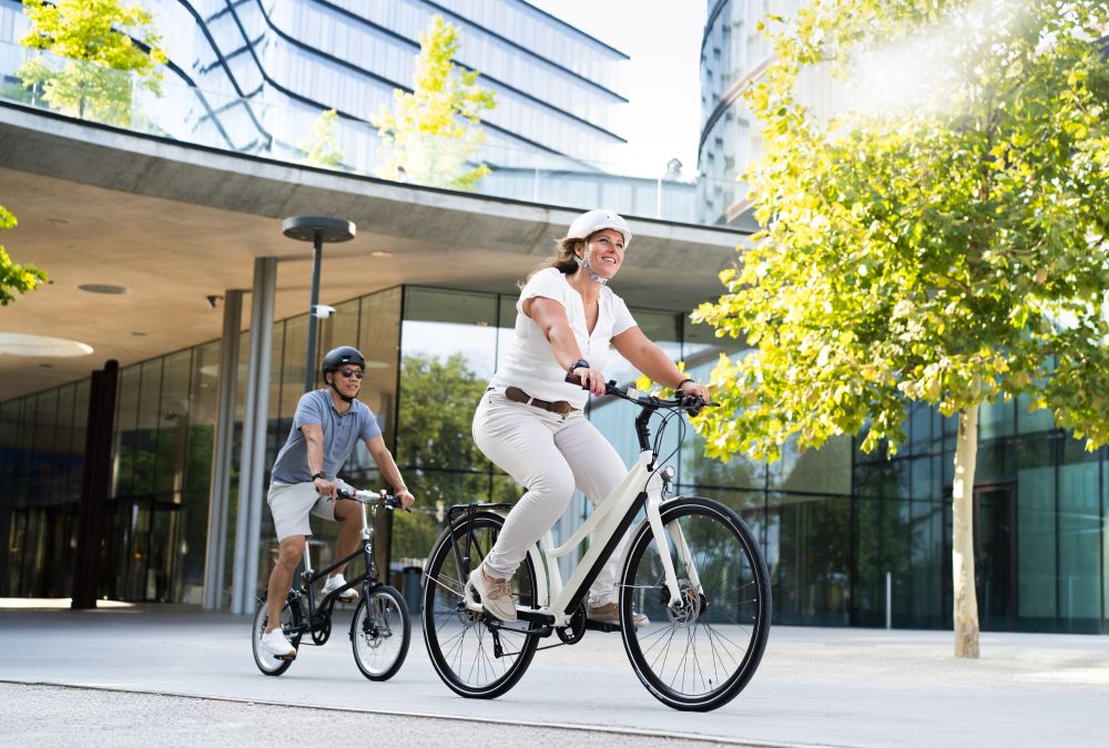 Herr und Frau fahren Rad vor Gebäude